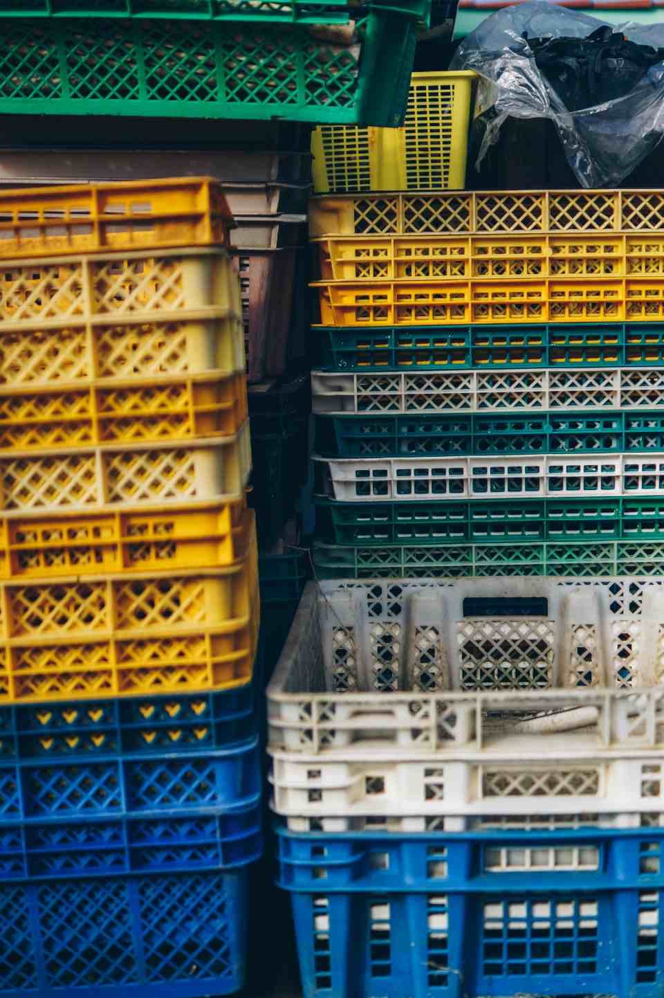 Colourful stackable crates arranged in warehouse corner